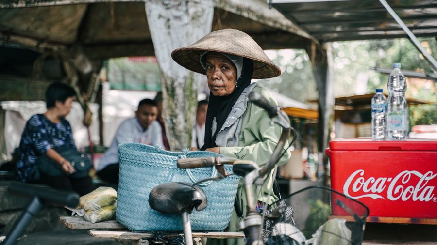 Pedagang pasar dengan sepeda dan keranjang